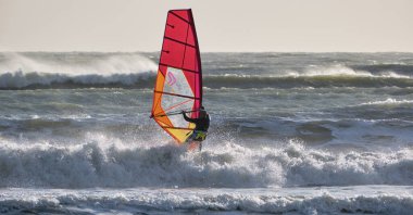 İtalya, Sicilya, Akdeniz, Marina di Ragusa (Ragusa ili); 7 Aralık 2021, denizde sörfçü - EDITORIAL