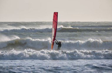 İtalya, Sicilya, Akdeniz, Marina di Ragusa (Ragusa ili); 7 Aralık 2021, denizde sörfçü - EDITORIAL