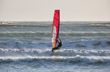 İtalya, Sicilya, Akdeniz, Marina di Ragusa (Ragusa ili); 7 Aralık 2021, denizde sörfçü - EDITORIAL