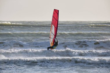 İtalya, Sicilya, Akdeniz, Marina di Ragusa (Ragusa ili); 7 Aralık 2021, denizde sörfçü - EDITORIAL