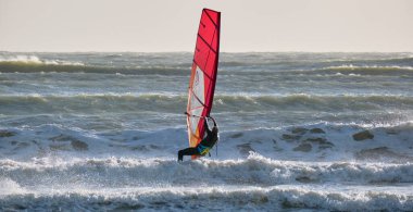 İtalya, Sicilya, Akdeniz, Marina di Ragusa (Ragusa ili); 7 Aralık 2021, denizde sörfçü - EDITORIAL