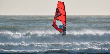 İtalya, Sicilya, Akdeniz, Marina di Ragusa (Ragusa ili); 7 Aralık 2021, denizde sörfçü - EDITORIAL