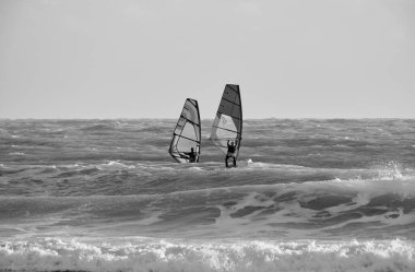 İtalya, Sicilya, Akdeniz, Marina di Ragusa (Ragusa ili); 7 Aralık 2021, denizde sörfçüler - EDITORIAL