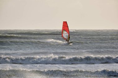 İtalya, Sicilya, Akdeniz, Marina di Ragusa (Ragusa ili); 7 Aralık 2021, denizde sörfçü - EDITORIAL