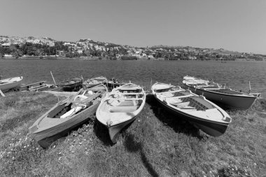 İtalya, Sicilya, Messina, Ganzirri kasabası, tahta balıkçı tekneleri ve Ganzirri gölünde bir balıkçı.