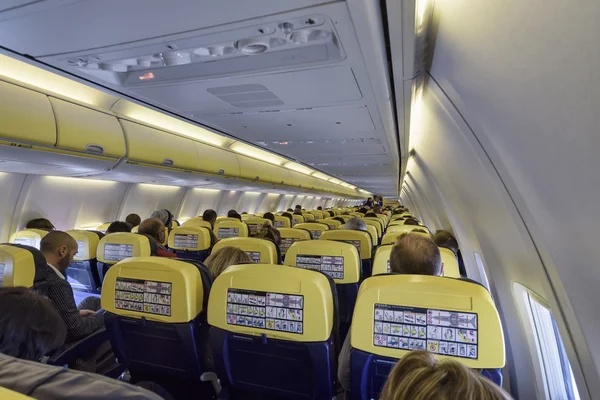 Italy; 19 January 2016, people in an airplane cabin with no smoking sign on - EDITORIAL