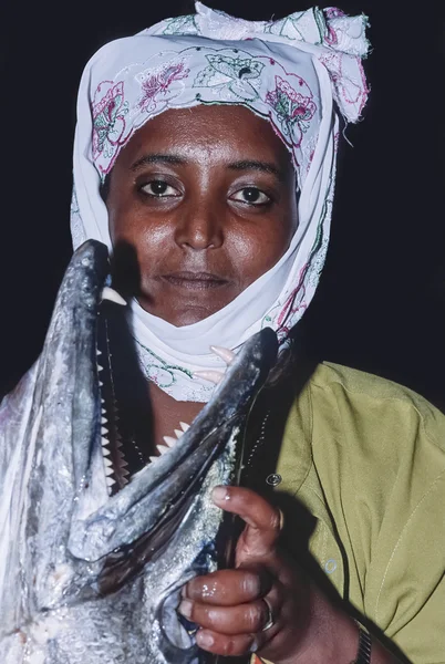 SUDAN, Sanghaneb Reef Lighthouse; 13 de novembro de 2002, mulher sudanesa de vestido tradicional segurando uma Grande Barracuda (FILM SCAN) - EDITORIAL — Fotografia de Stock