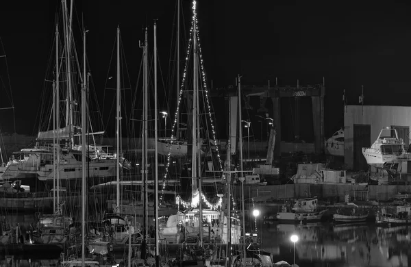 Itália, Sicília, Mar Mediterrâneo, Marina di Ragusa; 7 Dezembro 2015, vista de iates de luxo na marina à noite, luzes de Natal em um barco à vela - EDITORIAL — Fotografia de Stock