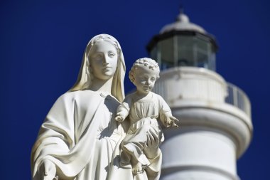 Italy, Sicily, Mediterranean sea, Punta Secca (Ragusa Province), the Madonna statue in the port and the lighthouse in the background clipart