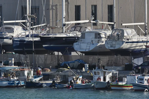 Itálie, Sicílie, Středozemní moře, Marina di Ragusa; 5. února 2016, dřevěných rybářských člunů a luxusní jachty na břeh v boatyard v přístavu - Editorial — Stock fotografie
