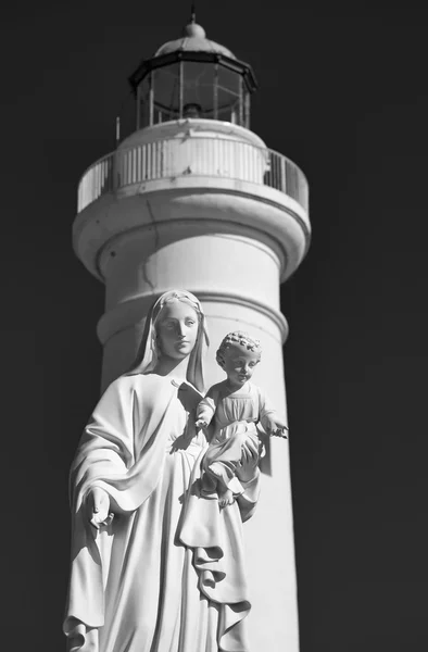 Italy, Sicily, Mediterranean sea, Punta Secca (Ragusa Province), the Madonna statue in the port and the lighthouse in the background — Stock Photo, Image