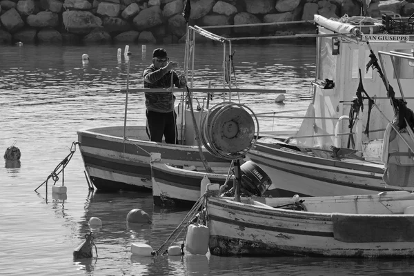 Italien, Sizilien, Mittelmeer, Punta secca (Provinz Ragusa); 02. Februar 2016, Fischer bei der Arbeit an seinem hölzernen Fischerboot im Hafen - Leitartikel — Stockfoto