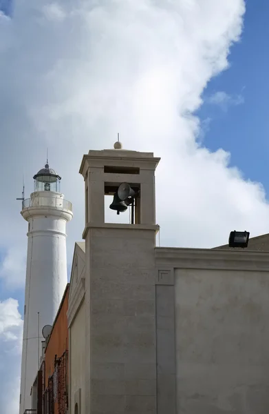 Италия, Сицилия, Средиземное море, Пунта-Секка (Ragusa Province), вид на колокольню церкви и маяк — стоковое фото