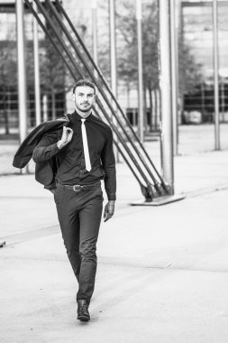 Yakışıklı, şık, genç bir iş adamı. Açık havada poz veriyor.