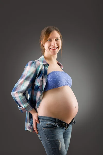 Zwangere vrouw op grijze achtergrond — Stockfoto