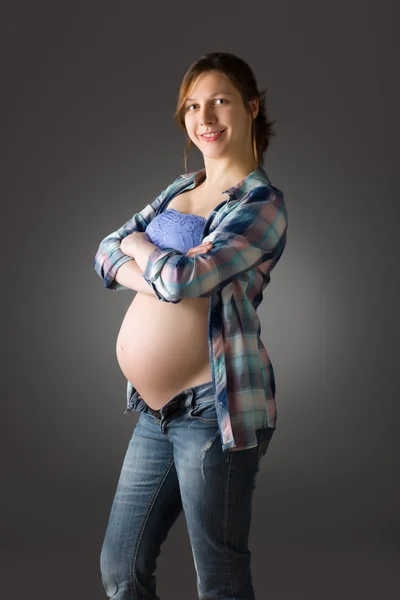 Zwangere vrouw op grijze achtergrond — Stockfoto