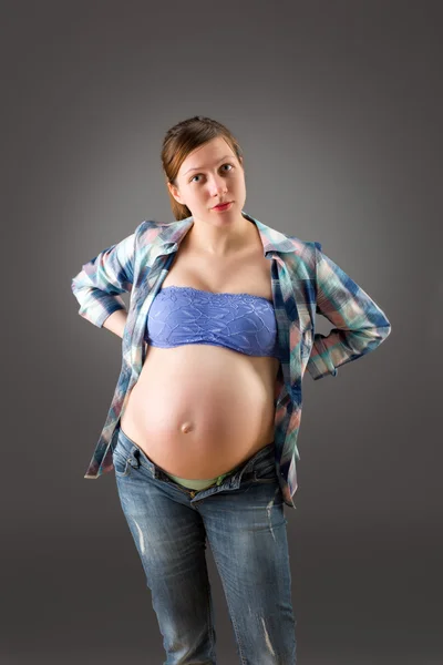 Kobieta w ciąży na szarym tle — Zdjęcie stockowe