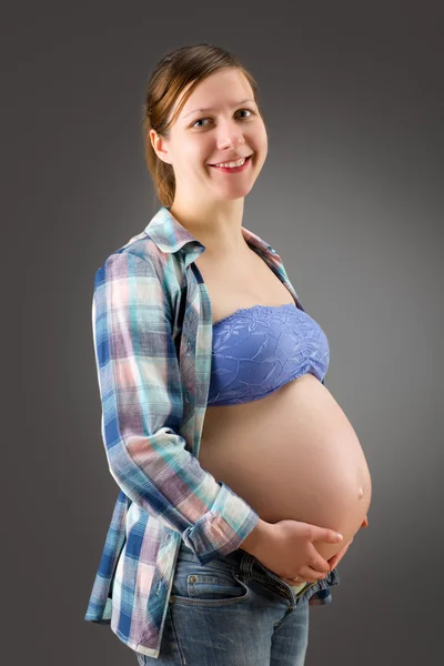 Zwangere vrouw op grijze achtergrond — Stockfoto