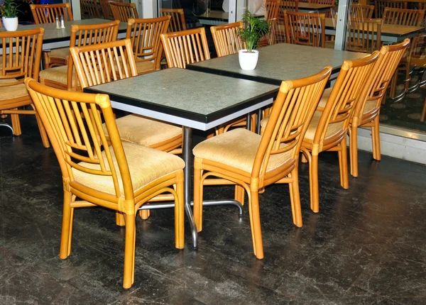 Glass table and wooden chairs — Stock Photo, Image