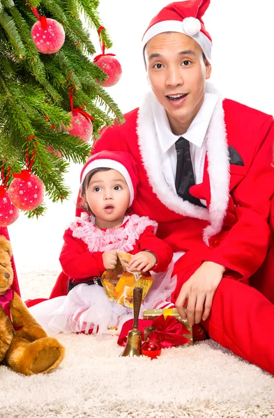 Familia feliz en la víspera de Navidad en casa sentado cerca de abeto decorado Imágenes de stock libres de derechos