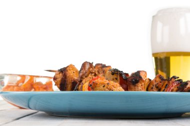 Bazı Şaşlık tükürür mavimsi tabakta bir bira ile dekore edilmiş 