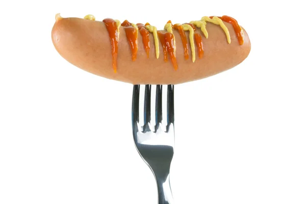 Saucisse crue décorée de moutarde et de ketchup percée sur une fourchette — Photo