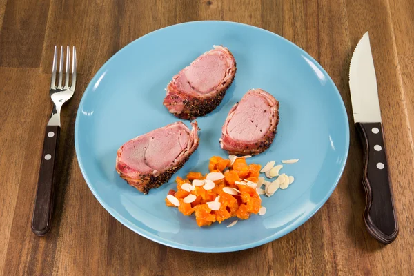 Perspective view from a dish with roast pork and vegetables on a — Stock Photo, Image