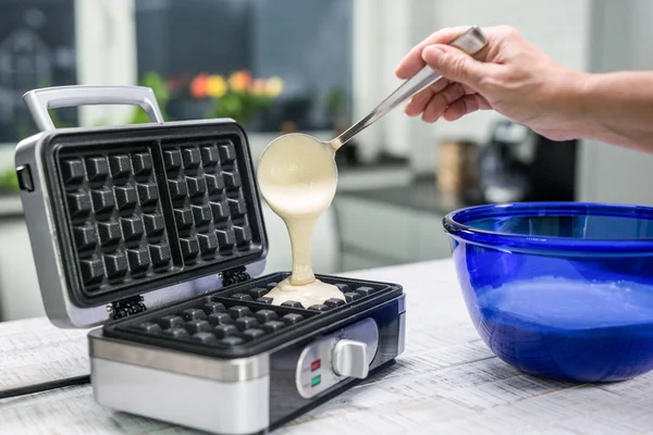 Mujer mano está vertiendo la masa en una plancha de gofres en su kitch moderno — Foto de Stock