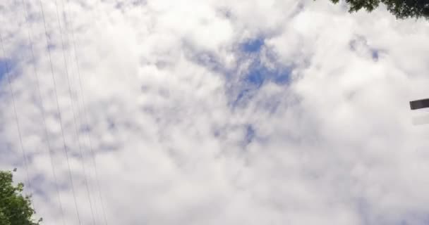 Un voyage sur une route le long de lignes électriques avec un ciel nuageux et quelques arbres. Le ciel et les arbres bougent tout le temps . — Video