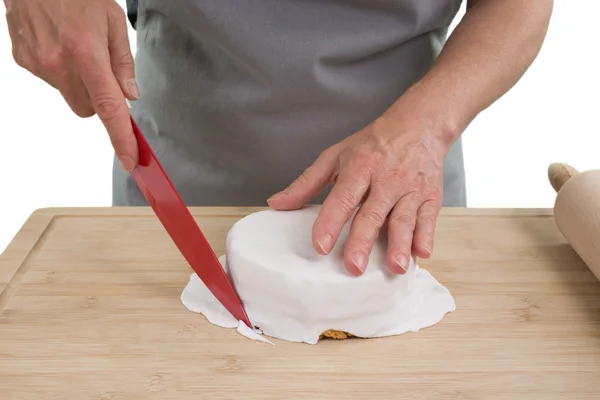 Kobieta kucharz jest cięcia ciasta nożem duże płyty drewniane, na białym tle — Zdjęcie stockowe