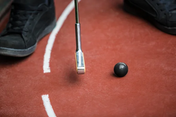 Perspektive von einem Minigolfspieler mit einem Eisenschläger und einem — Stockfoto