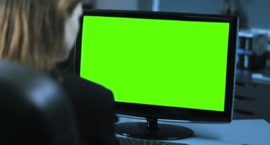 4k: bir genç kadın Yöneticisi önünde bir monitör ofisinde çalışıyor. Yüzüne karşı daha sonra tekrar monitör renk yeşil monitörden odağı taşır. 