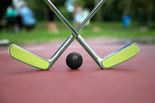 Minigolf scenery consist of two crossed minigolf rackets and a b — Stock Photo, Image