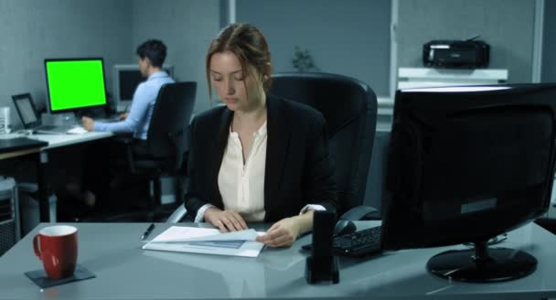 4K: A young controller is analyzing some financial reports in an office. — Stock Video