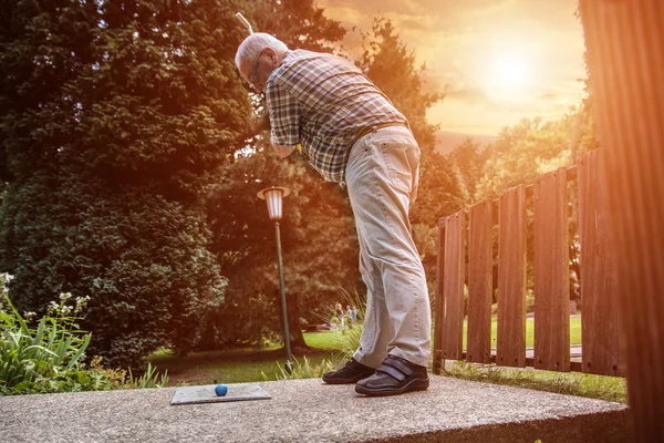 Starszy mężczyzna w grze minigolf. Obraz Stockowy