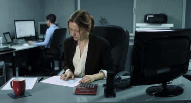 4 k: 2 人の女性従業員が近代的なオフィスに彼女のコンピューターに取り組んでいます。財務管理でフォア グラウンドで若い女性を深めていく — ストック動画