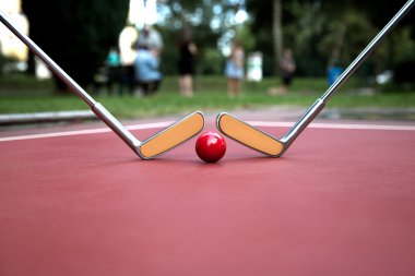 Minigolf demir raketleri ve bir mahkeme zemin kırmızı bir baloda.