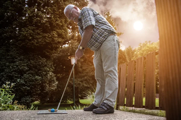 Two pensioners at a minigolf court playing minigolf — Stock Photo, Image