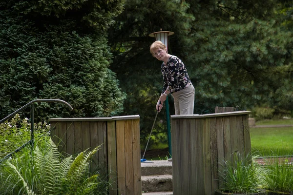 Dois pensionistas em uma corte de minigolfe jogando minigolfe — Fotografia de Stock