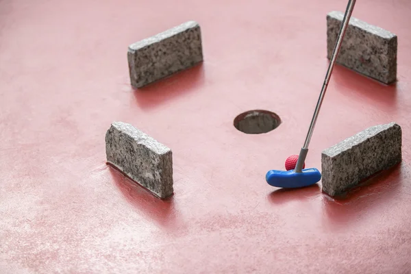 Minigolf speler raakt een bal binnen een matrix van obstakels — Stockfoto