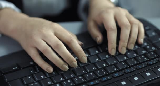 4K: Una vista de cerca desde las manos femeninas de escritura rápida en un teclado negro . — Vídeo de stock