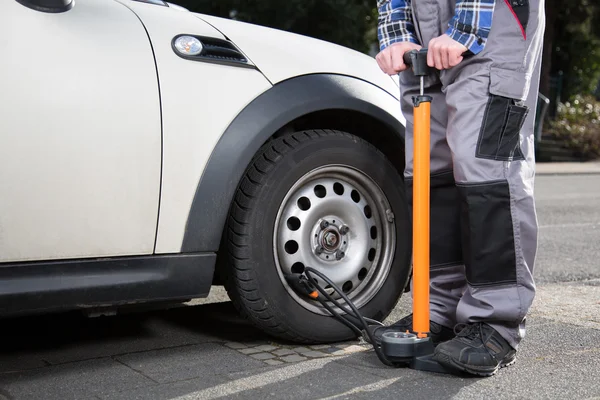 A man is refilling a car wheel — Stock Photo, Image