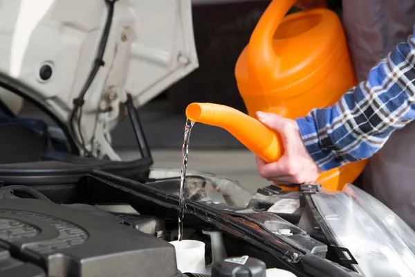 Fylla färskt vatten in i bil motor tanken — Stockfoto