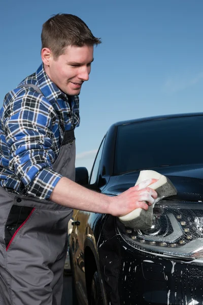 Cleaning a car on the street with a sponge — Stock Photo, Image