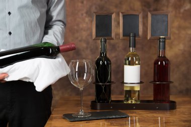 Garson yağan kırmızı şarap bir bardak başlar.