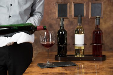 Kırmızı şarap bir gla dökülen bir garson dan bir sahne