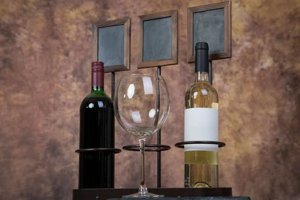 Empty wine glass infront of wine bottles — Stock Photo, Image