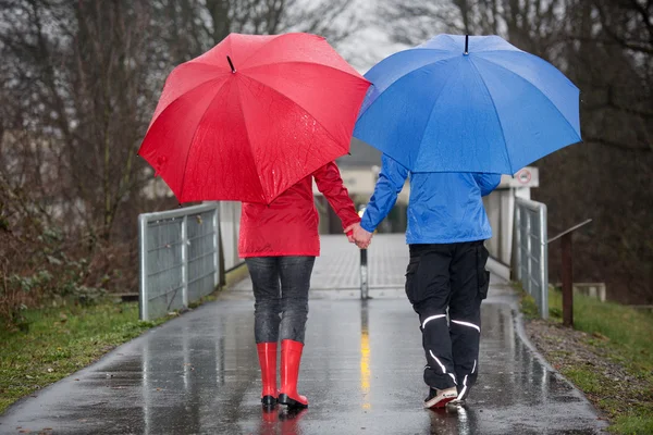 Çift el el yağmurda yürümek — Stok fotoğraf