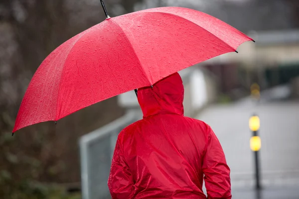 Regen wandeling met haar paraplu en regenjas — Stockfoto