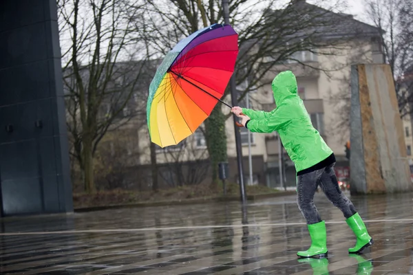 Renkli bir şemsiye ile kadın bir fırtına karşı savaşır — Stok fotoğraf